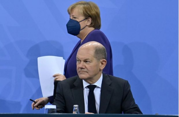 La canciller Angela Merkel pasa junto a Olaf Scholz antes de una rueda de prensa que dieron el 2 de diciembre de 2021 en Berlín John MacDougall Pool/AFP