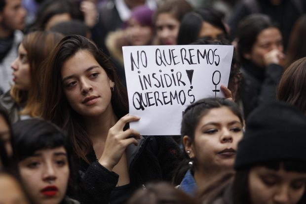 Grupo de mujeres en una marcha sosteniendo un cartel que exige igualdad y participación en temas de género en Chile.