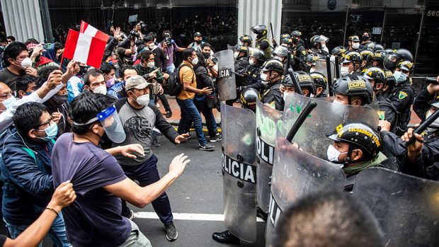 Protestantes y policías enfrentandose en las calles de Perú 