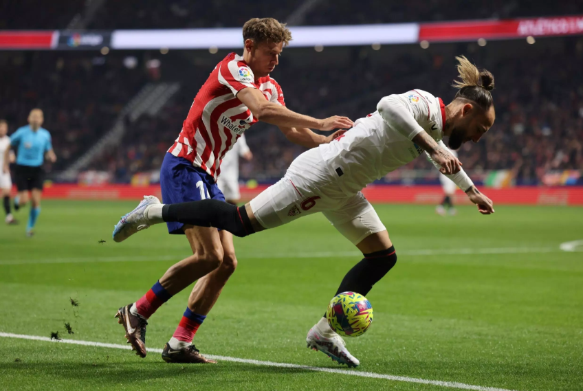 Los centrocampistas del Atletico de Madrid Marcos Llorente (izq.) y del visitante Sevilla Nemanja Gudelj protagonizan una jugada en un partido de la liga española de fútbol el 4 de marzo de 2023 © Thomas Coex / AFP