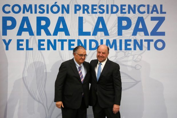 Francisco Huenchumilla y Alfredo Moreno, atrás de ellos una gigantografía que dice: Comisión Presidencial para La Paz y el Entendimiento