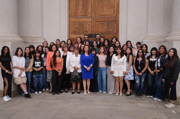 Autoridades de Gobierno junto a un grupo de mujeres en el Frontis de La Moneda.