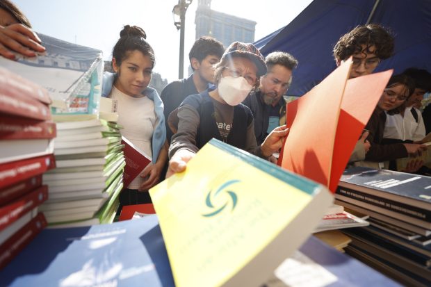 Personas revisan libros en un stand de ejemplares variados.