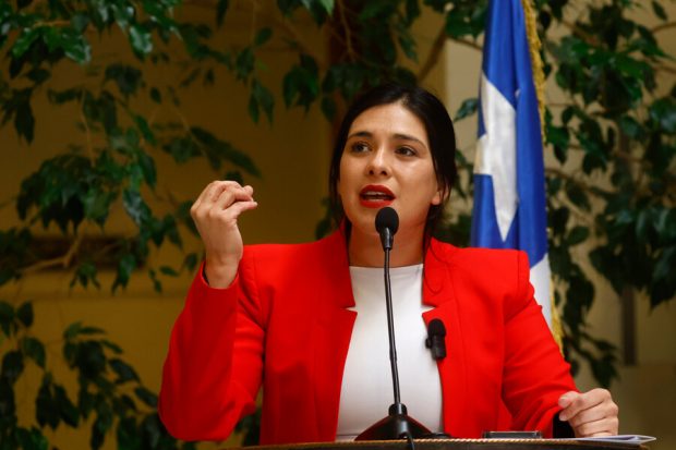Punto de prensa de la diputada Karol Cariola, quien luce un blazer rojo y blusa blanca.