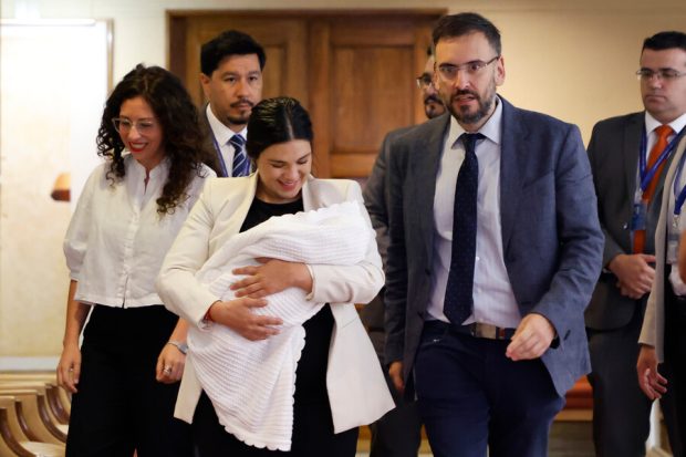 La diputada Karol Cariola y el diputado Tomas de Rementeria, junto a su hijo, en su ingreso a la Cámara de Diputados