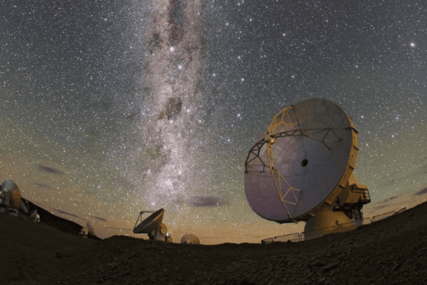 Observatorios astronómicos bajo un cielo estrellado, con la Vía Láctea brillando en el fondo.
