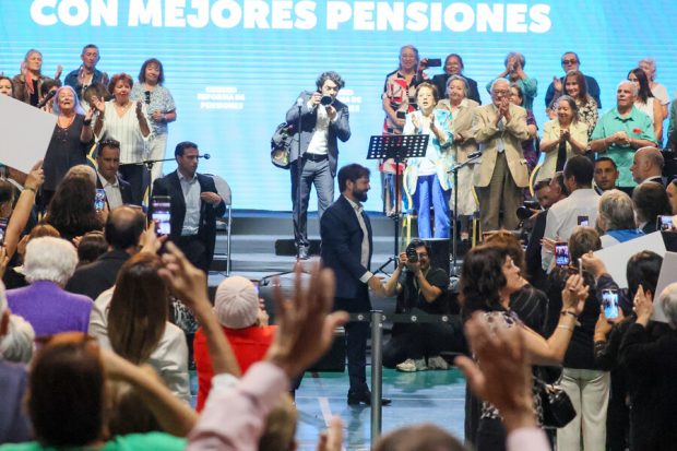 Presidente Boric abajo del escenario de músicos y en medio de las personas del público.