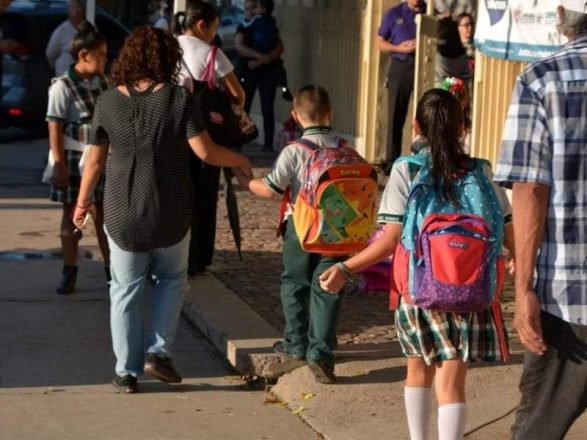 niños volviendo a clases, en la iamgen aparecen dos niños caminando con mochilas.