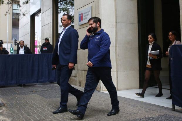 Boric hablando por teléfono mientras camina.