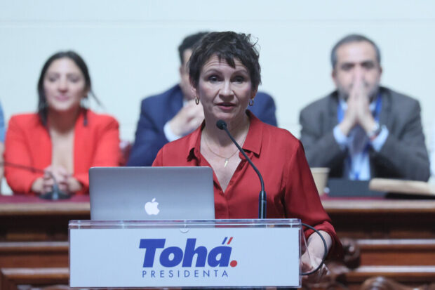 Alocución de Carolina Tohá en un podio que dice "Tohá presidenta".