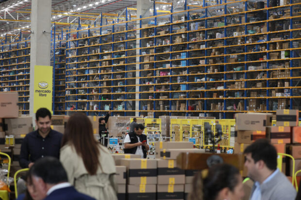 En la imagen se ven múltiples cajas y objetos con la cinta amarilla y logo de Mercado Libre