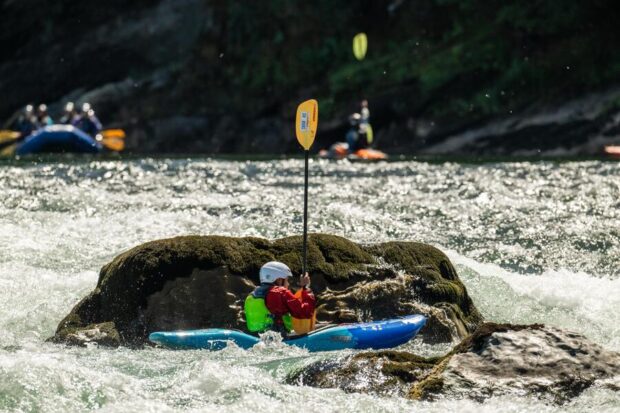 Personas haciendo kayak en un rio.