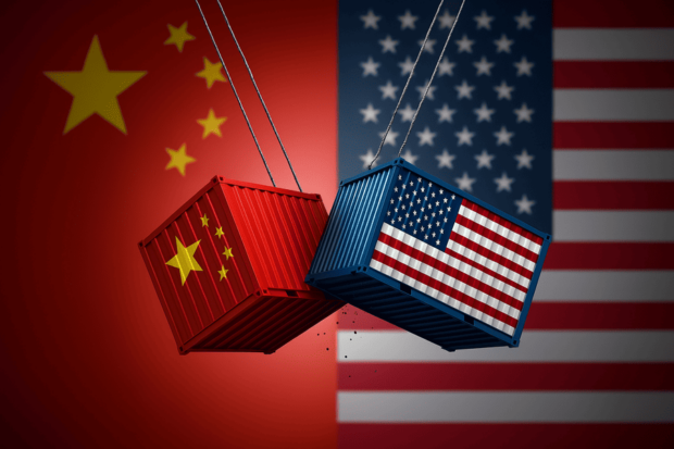 Ilustración digital de dos contenedores de carga, uno con la bandera de China y otro con la de Estados Unidos, colisionando como péndulos frente a los colores de sus respectivas banderas nacionales. Representa la tensión comercial entre ambos países
