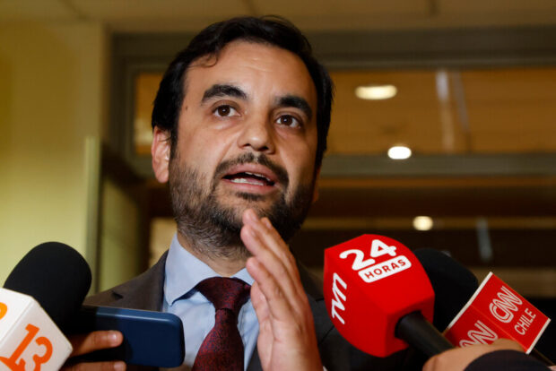 Jaime Gajardo rodeado de micrófonos de distintos medios de comunicación.