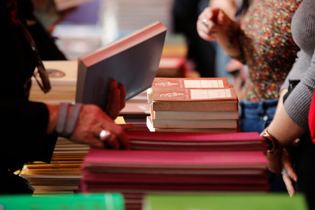Variedad de libros y manos que los sostienen.