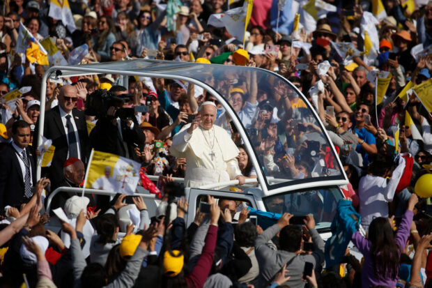 El Papa Francisco en su Papa movil rodeado de adeptos.
