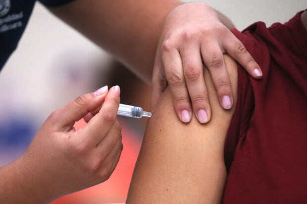 Plano detalle de la aplicación de una vacuna en el brazo