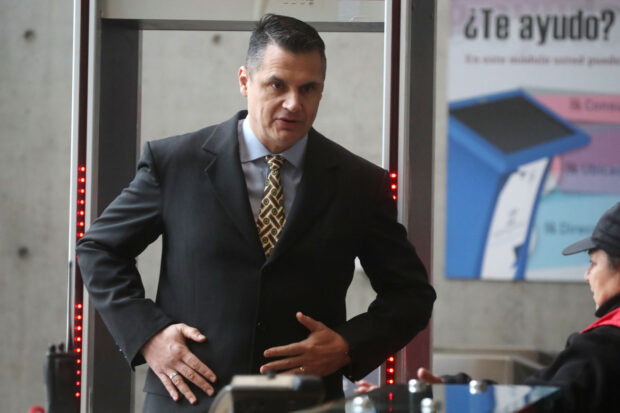 Claudio Crespo, exoficial de Carabineros de Chile, pasando por control de seguridad en el ingreso a un edificio institucional.