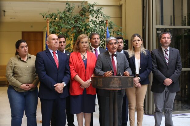 Bancada de diputados y diputadas de la UDI frente a un podio.