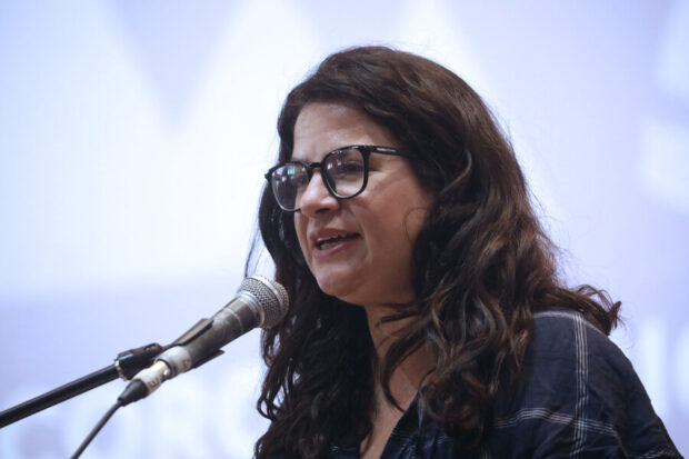 Ministra Orellana frente a un micrófono dando un discurso.