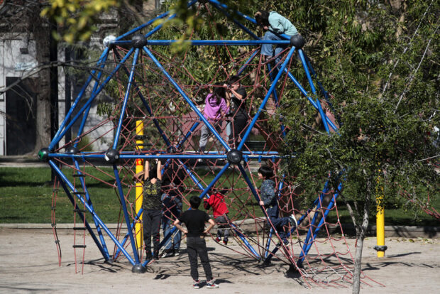 Niños y niñas jugando en un parque.