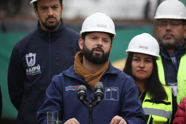 Presidente Boric dando un discurso con casco blanco de construcción.
