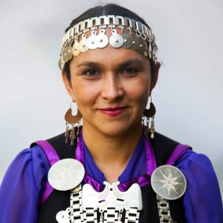 Rosa Catrileo, abogada y exconvencional mapuche, es una destacada defensora de los derechos del pueblo mapuche en Chile. En la imagen aparece con vestimenta e insignias tradicionales como el trarilonko (cintillo de plata) y el trapelakucha (pectorales), símbolos de identidad y resistencia cultural. Catrileo ha abogado por el reconocimiento constitucional de los pueblos originarios y la plurinacionalidad del Estado chileno.