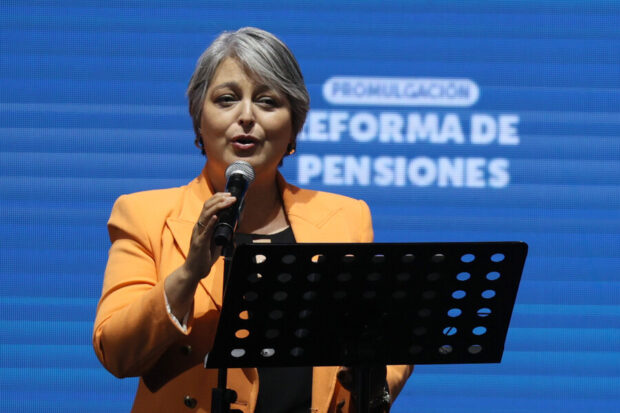Jeannette Jara habla desde un podio, atrás de ella una gigantografía que dice "Reforma de pensiones".