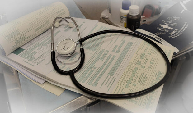 Un formulario médica encima de un escritorio, sobre el documento se ve un estetoscopio.