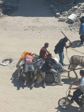 Gazatíes asesinados en las cercanias de un centro de distribución de la GHF, siendo trasladados en carretas