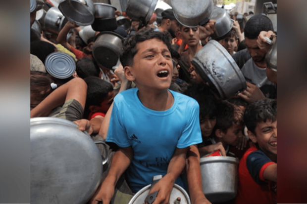 Grupo de palestinos, peleando por un poco de comida en uno de los pocos puntos de reparto