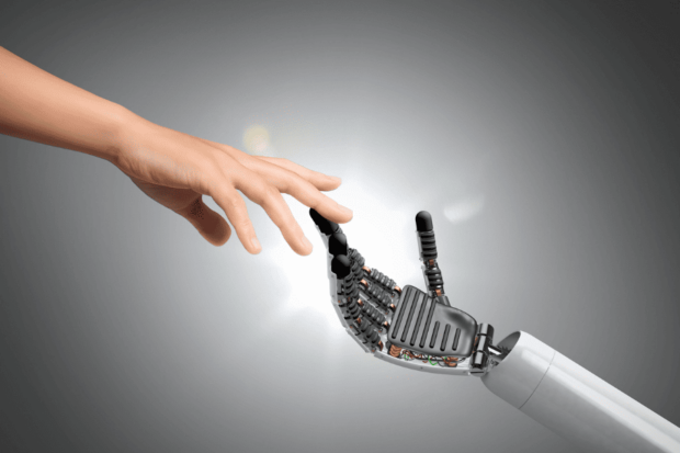 Mano humana tocando la mano robótica, simbolizando la conexión entre inteligencia artificial y humanidad.