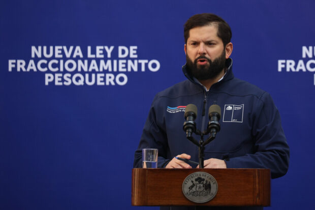 Presidente Gabriel Boric durante una alocución, detrás de él una gigantografía que dice: "Nueva Ley de Fraccionamiento Pesquero".