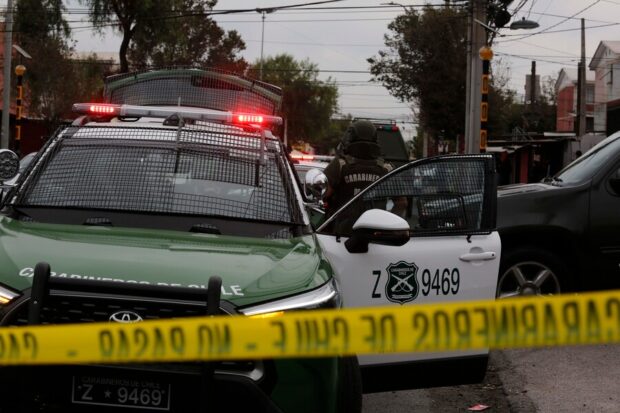 Cinta amarilla de Carabineros y una patrulla policial de la misma institución.