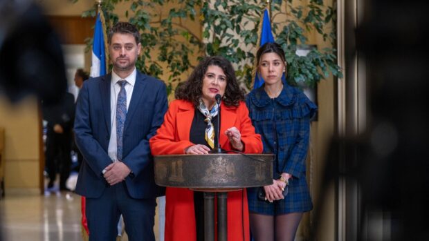 a diputada Ana María Bravo con micrófono, flanqueada por los parlamentarios Daniel Manoucheri y Daniella Cicardini, presentando una iniciativa de ley en el Congreso chileno.