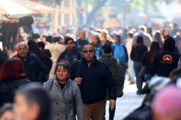 Vida diario en Santiago. Personas caminan de día en la calle.