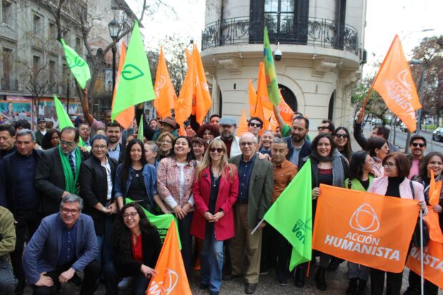 Entre banderas naranjas y verdes se ve un grupo grande de dirigentes y militantes de la Federación Regionalista Verde Social y Acción Humanista tras la inscripción del pacto electoral parlamentario.
