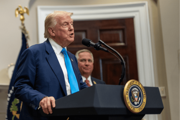Presidente de Estados Unidos, Donald Trump, se dirige al público desde un podio con el escudo del país.