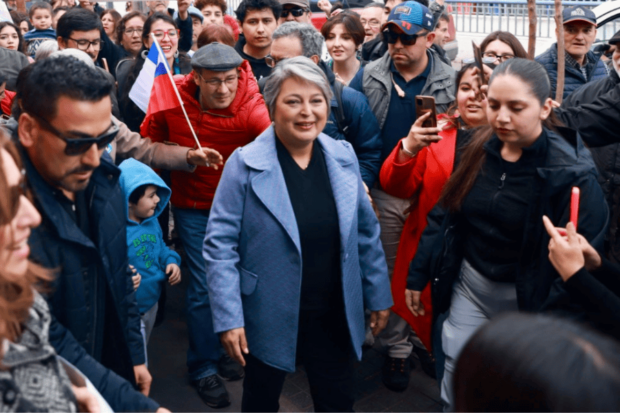 Candidata del pacto Unidad por Chile, Jeannette Jara, camina por la calle rodeada de adherentes.