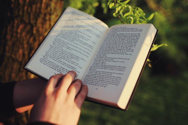 Imagen de una persona sosteniendo un libro abierto con su mano