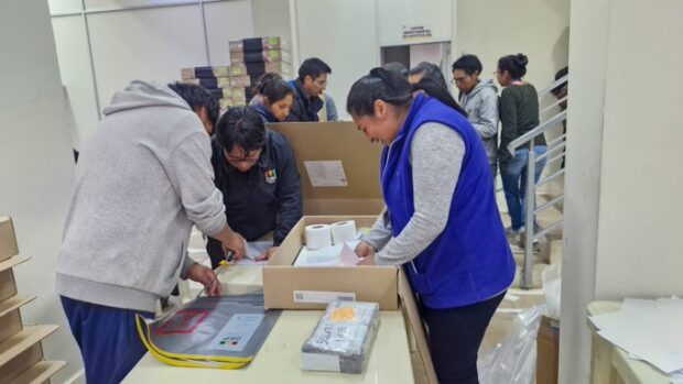 Equipos del tribunal supremo electoral boliviano preparando las urnas y los votos para este domingo