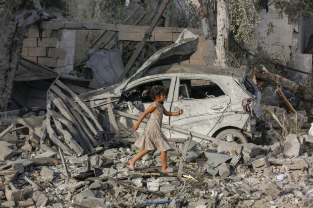 Niña palestina se ve corriendo entre los escombros de Gaza.