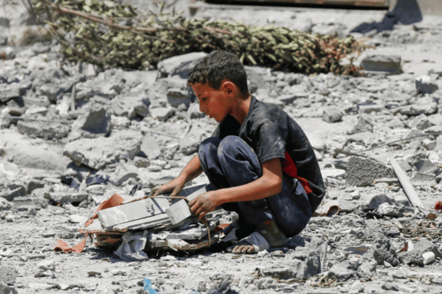 Niño gazatí entre los escombros de Gaza.