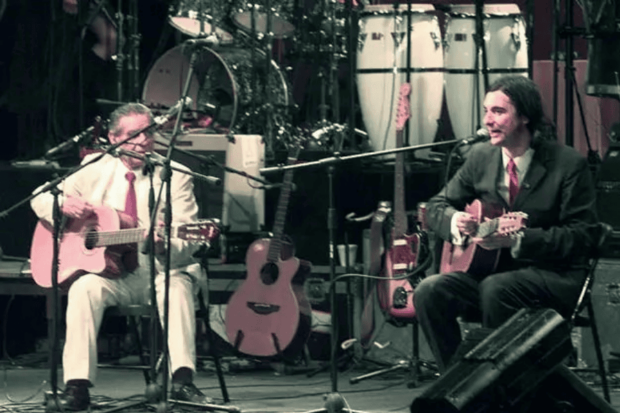 Roberto Parra y Alvaro Henríquez sobre el escenario, tocando guitarra