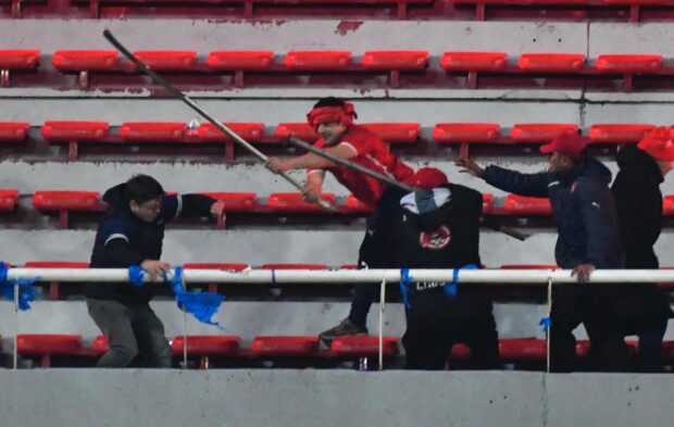 Hinchas de Independiente golpeando a hinchas de la Universidad de Chile durante el partido de vuelta de los octavos de final de la Copa Sudamericana en el estadio Libertadores de Américas de Buenos Aires, Argentina. Fotobaires/Photosport.