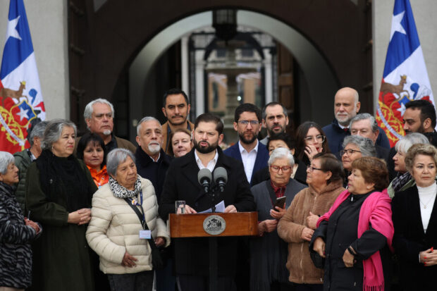 Boric habla desde un podio rodeado de adultos mayores.