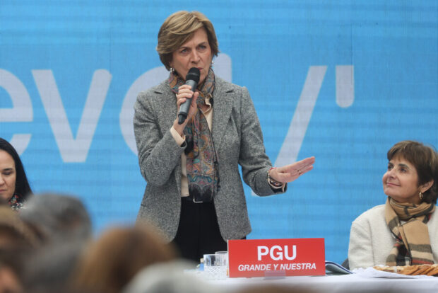Evelyn Matthei hablando de pie con un micrófono en la mano.