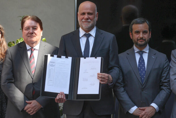 Álvaro Elizalde muestra a la cámara un documento oficial. A su lado posan junto a el Ricardo Blanco y Jaime Gajardo.