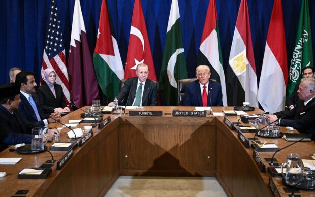 Mesa en C con Donald Trump y el presidente de Turquia a la cabeza, detrás de ellos banderas de distintas países. Sentados a sus costados dirigentes de países árabes.