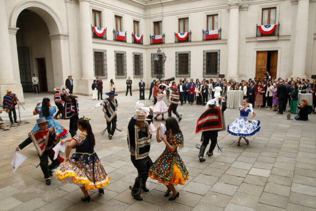 Varias parejas bailando cueca en el esquinazo de La Moneda.